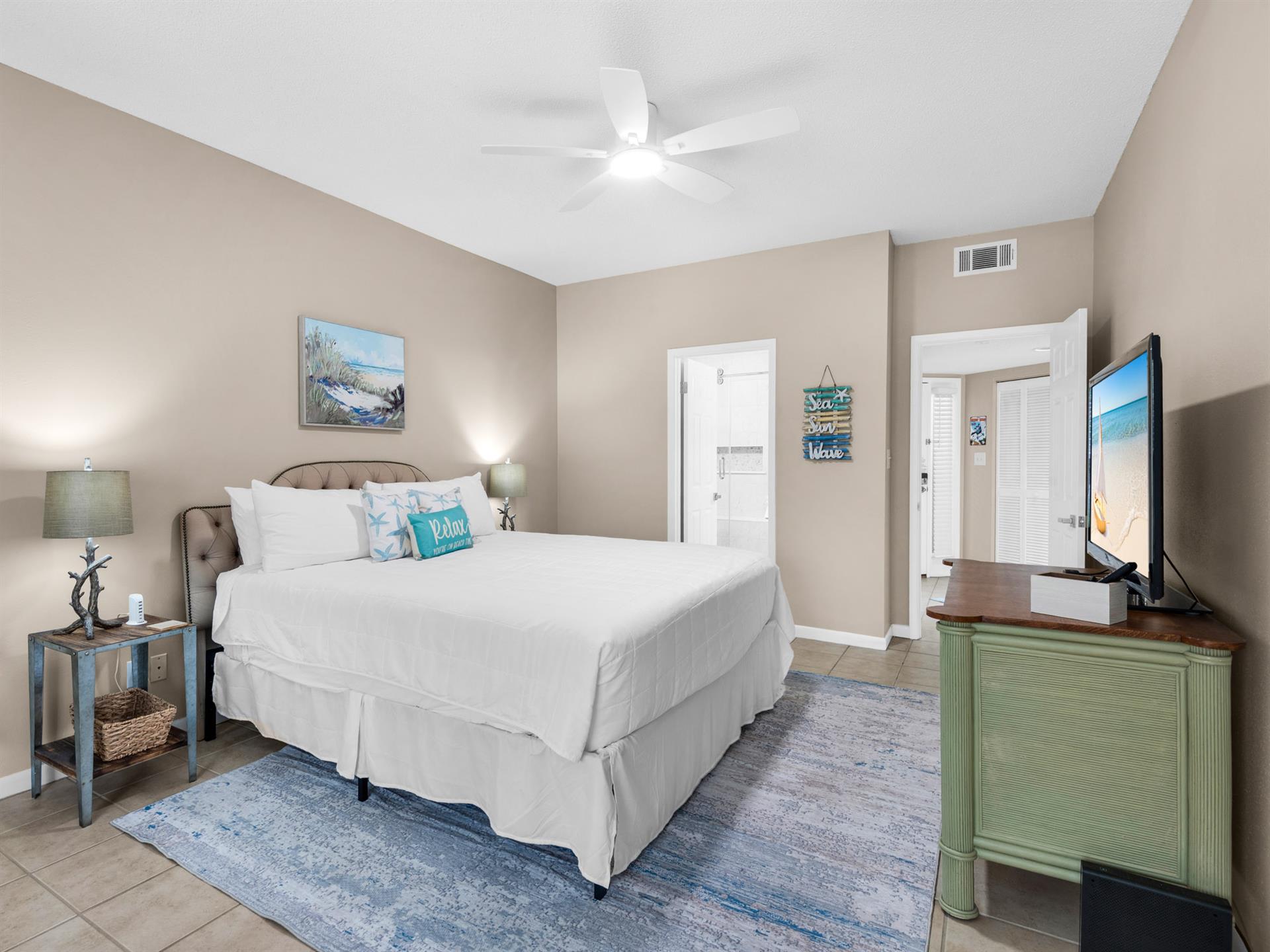 Bedroom 1 Drift off in your coastal retreat with crisp linens, oceanthemed touches, and modern comfort—complete with ceiling fan and flatscreen TV.