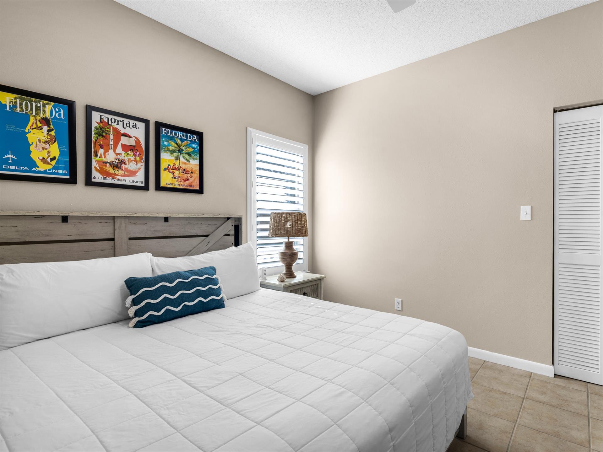 Bedroom 2 Your coastalthemed bedroom features a comfortable queen bed with crisp white linens and charming Florida vintage posters creating the perfect beachy retreat.