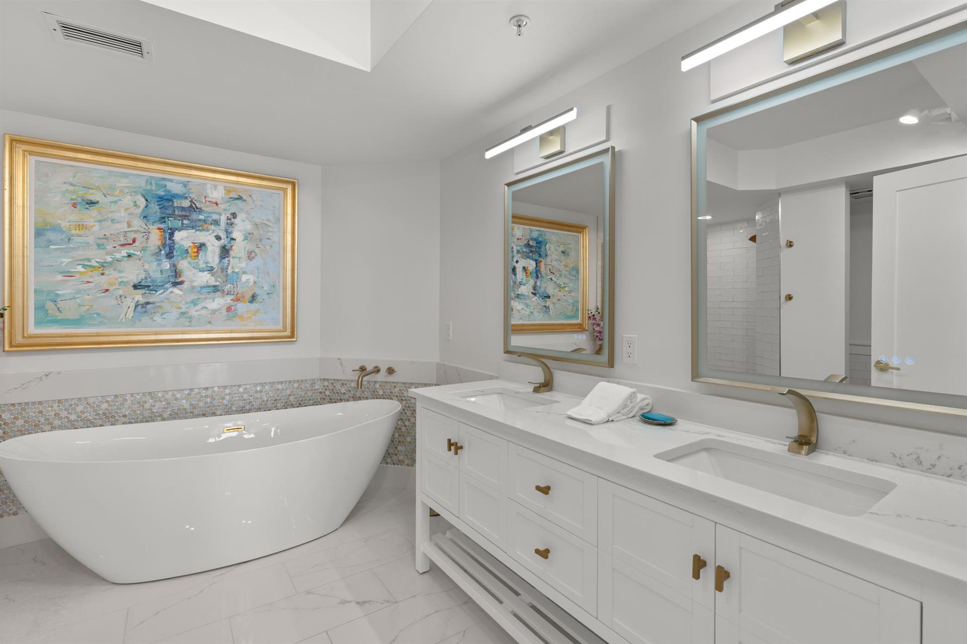 Unwind in your spalike bathroom featuring a luxurious soaking tub and elegant marble vanity for ultimate relaxation.
