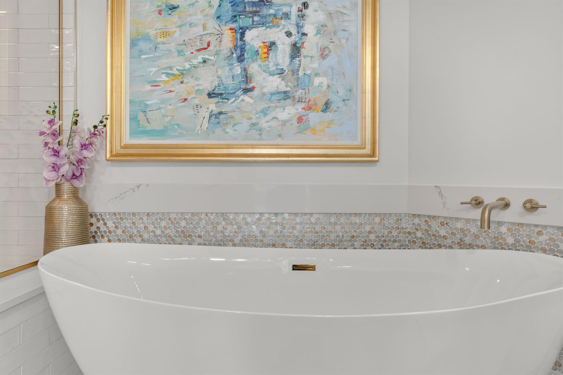 Soak away your stress in this elegant freestanding tub, surrounded by beautiful artwork and luxurious finishes for your perfect retreat.