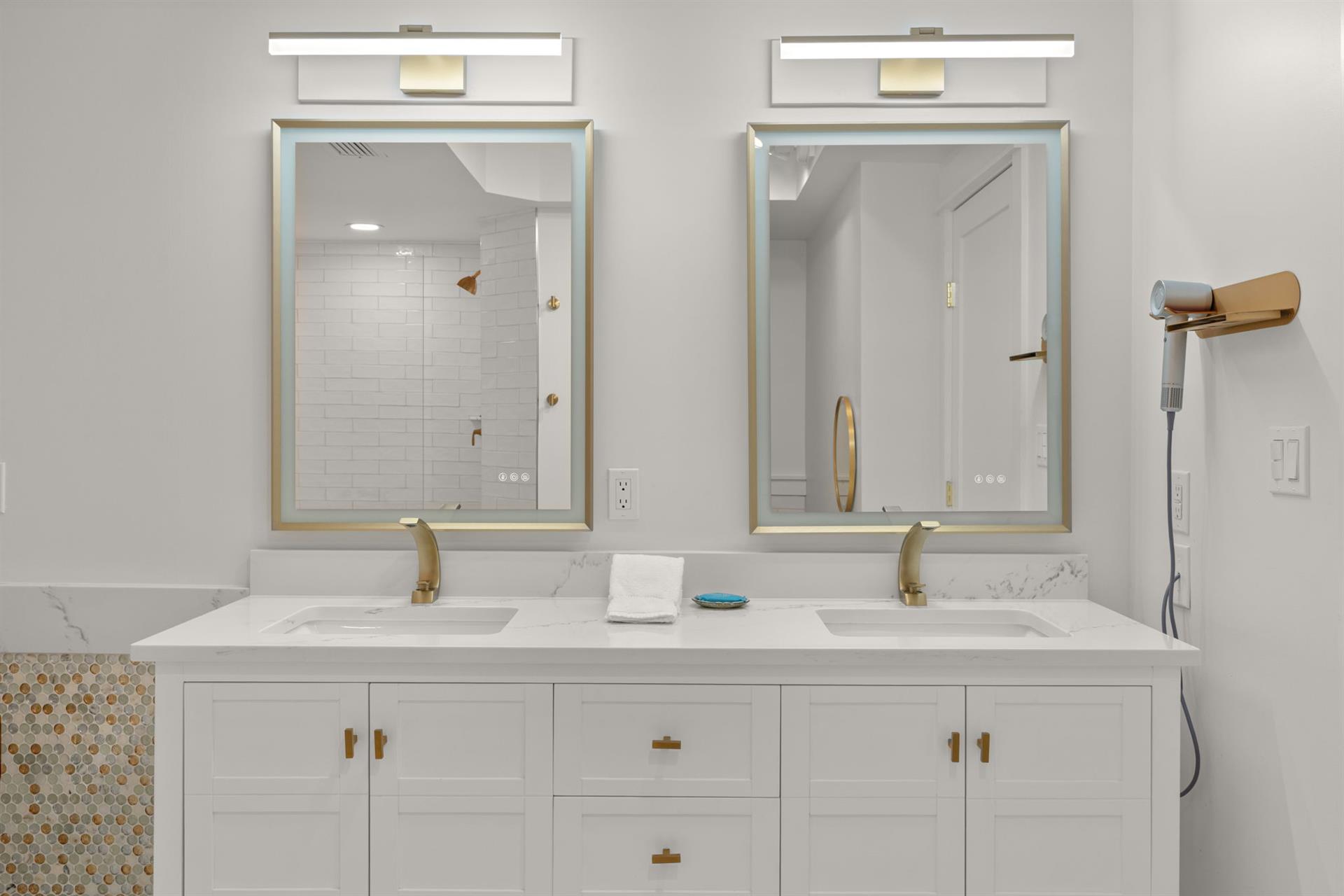 Your elegant dualvanity bathroom features marble countertops, brass fixtures, and a spalike shower for ultimate relaxation.