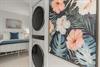 Your own private laundry room features a tropical floral accent wall, making chores feel like a breeze during your stay.