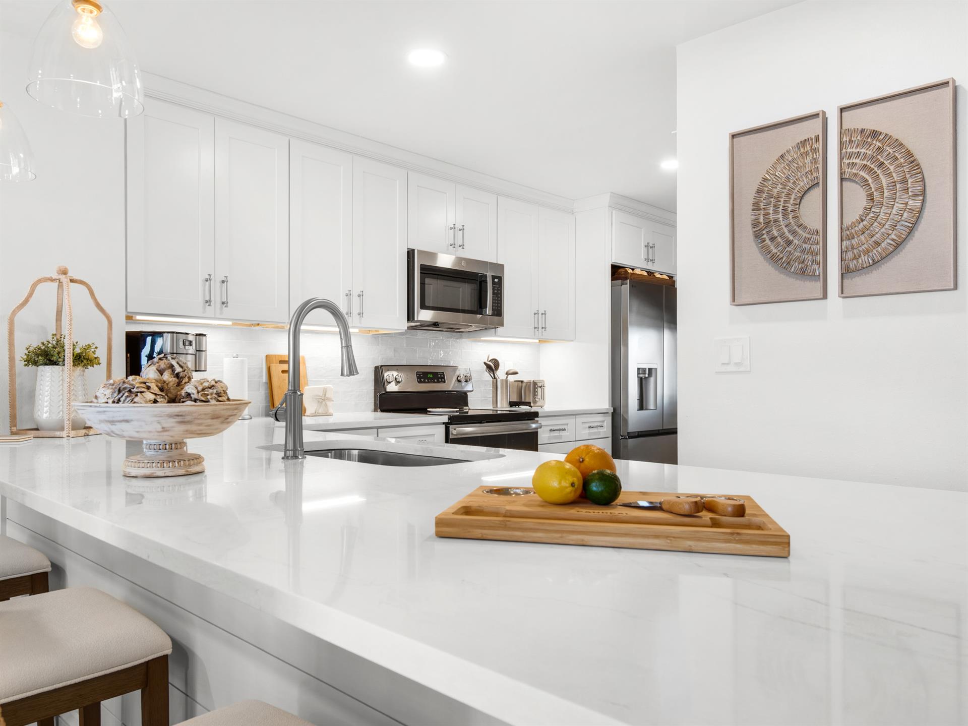 Your sleek modern kitchen awaits with pristine white countertops, stainless steel appliances, and thoughtful touches that make cooking a joy.