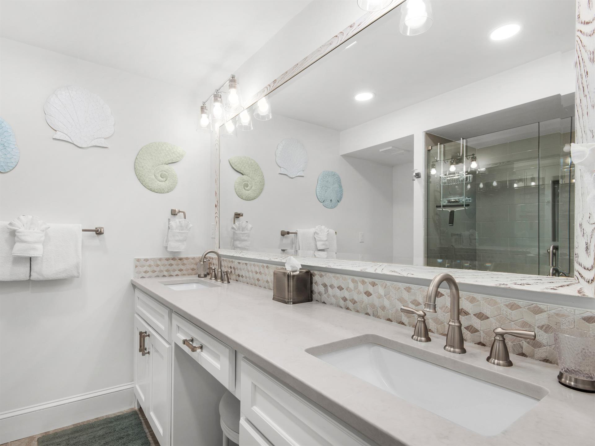 Bathroom 1  Pamper yourself in this elegant dualvanity bathroom featuring marble countertops, designer lighting, and a luxurious glassenclosed shower.