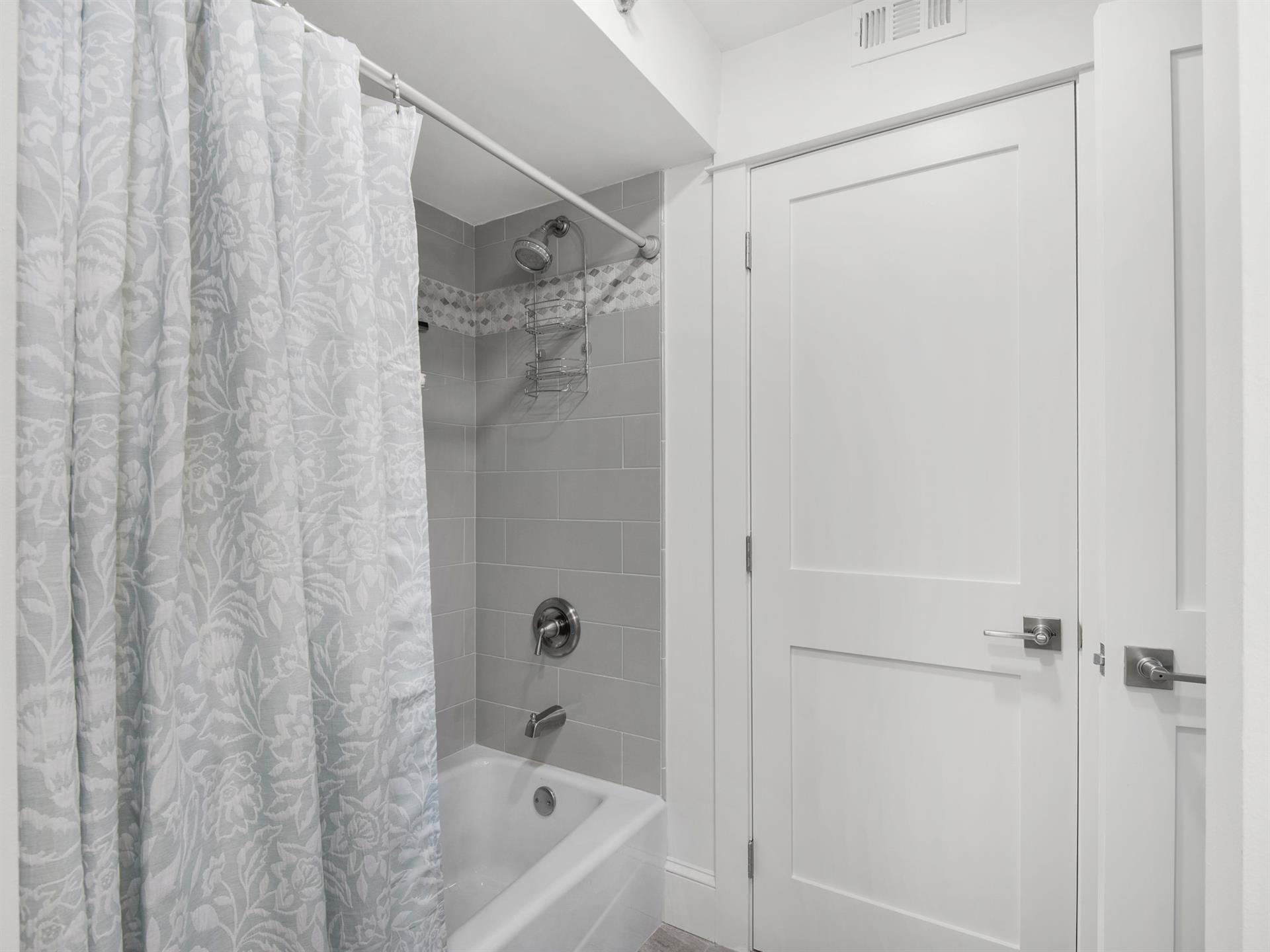 Bathroom 2  Unwind in your pristine bathroom featuring a relaxing tubshower combo with elegant gray tile and fresh linens.
