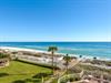 Pristine white sand beach stretches along emerald Gulf waters under endless blue skies, with convenient boardwalk access.