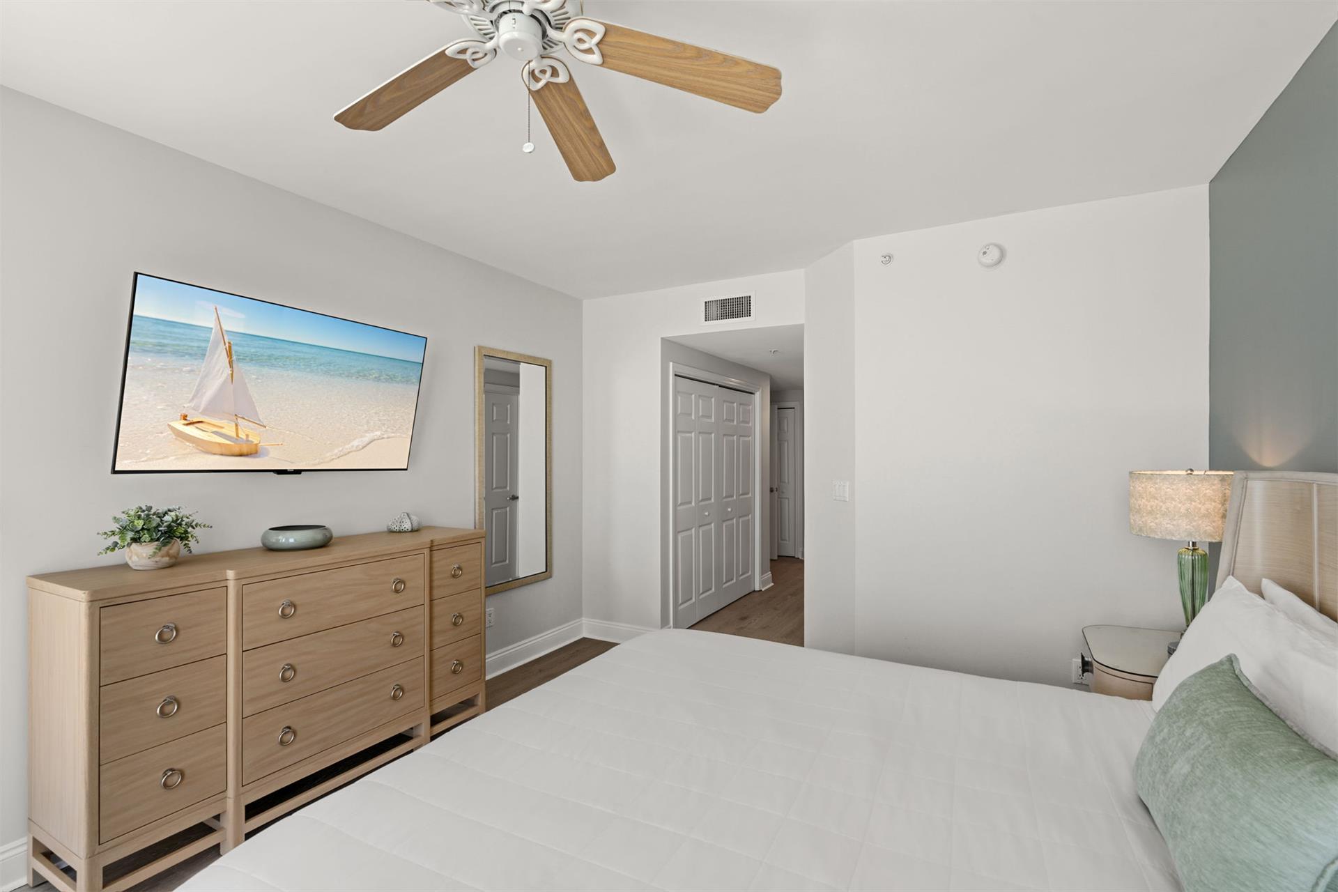 Unwind in your peaceful bedroom where coastal artwork and soft lighting create the perfect atmosphere for restful nights and relaxed mornings.