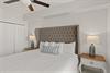Sink into your luxurious tufted headboard bed with crisp linens and cozy accent pillow for peaceful nights.