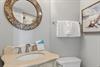 Refresh in your elegantly appointed bathroom featuring a stunning mosaic mirror, plush towels, and coastal artwork creating a spalike retreat.