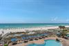 Beachfront resort with pristine white sand, turquoise waters, and pool area overlooking the Gulf Coast.