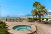 Tropical pool deck with hot tub and loungers leads to pristine beachfront paradise.