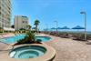 Beachfront resort featuring swimming pool, hot tub, and direct beach access with lounge seating.