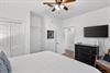 Your serene bedroom features a ceiling fan, flatscreen TV, and ample storage in the elegant black dresser for a comfortable stay.
