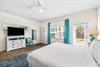 3rd Bedroom is the primary suite on the east end with a king bed, 45 TV,  walkin closet, ensuite full bathroom with a bathtubshower combination, and views of the pool area  door leading out to the