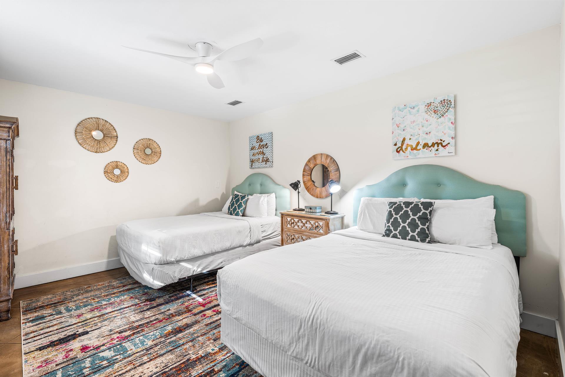East end of Seabreeze has a 2nd bedroom with 2 queen beds  adjacent full bathroom with a walkin shower.   TV located above the chest of drawers