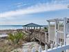 Beachfront gazebo and boardwalk provide direct access to pristine white sand and emerald waters.