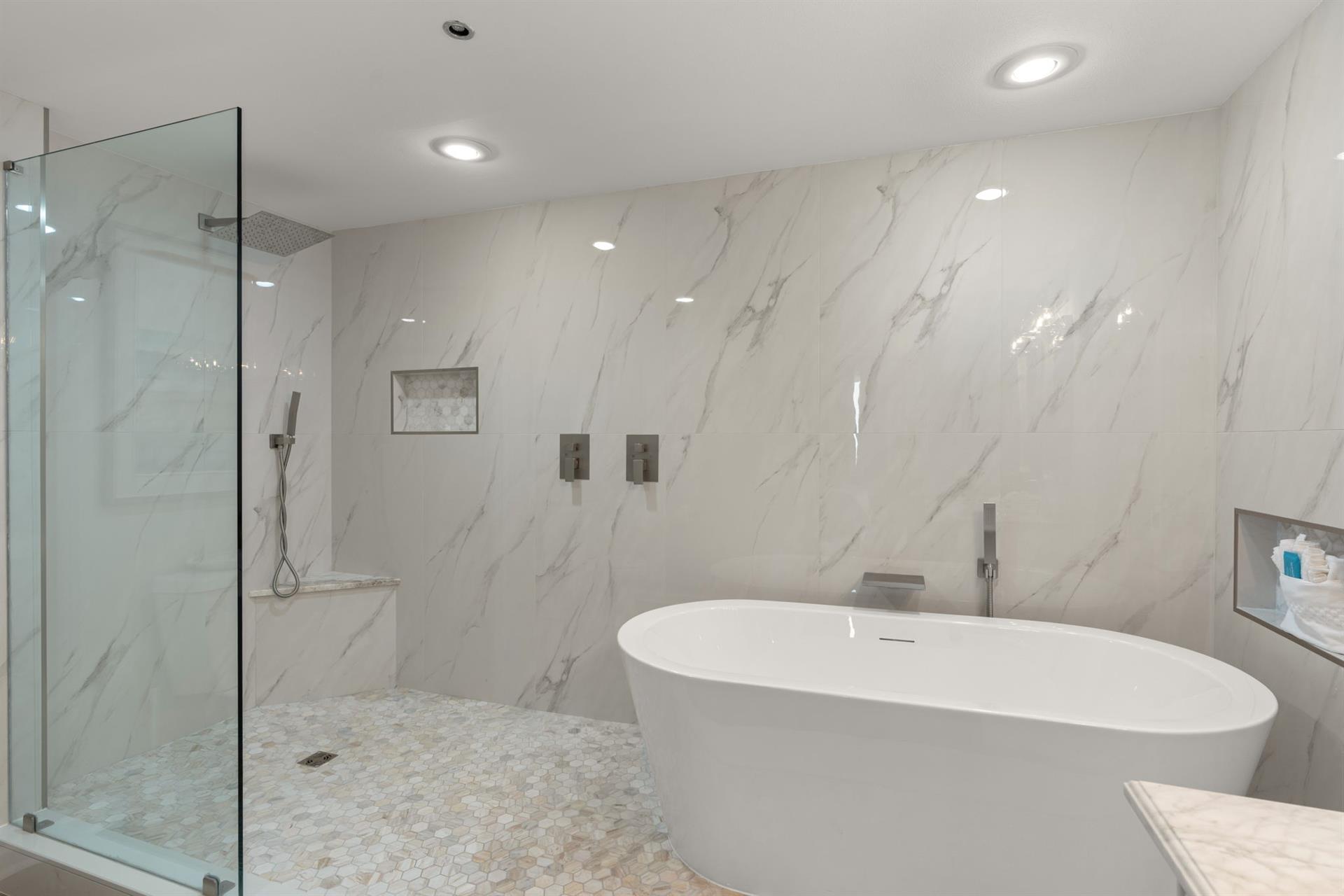Slip into your own spa like bathroom featuring a luxurious soaking tub and rainfall shower.