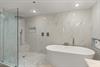Slip into your own spa like bathroom featuring a luxurious soaking tub and rainfall shower.