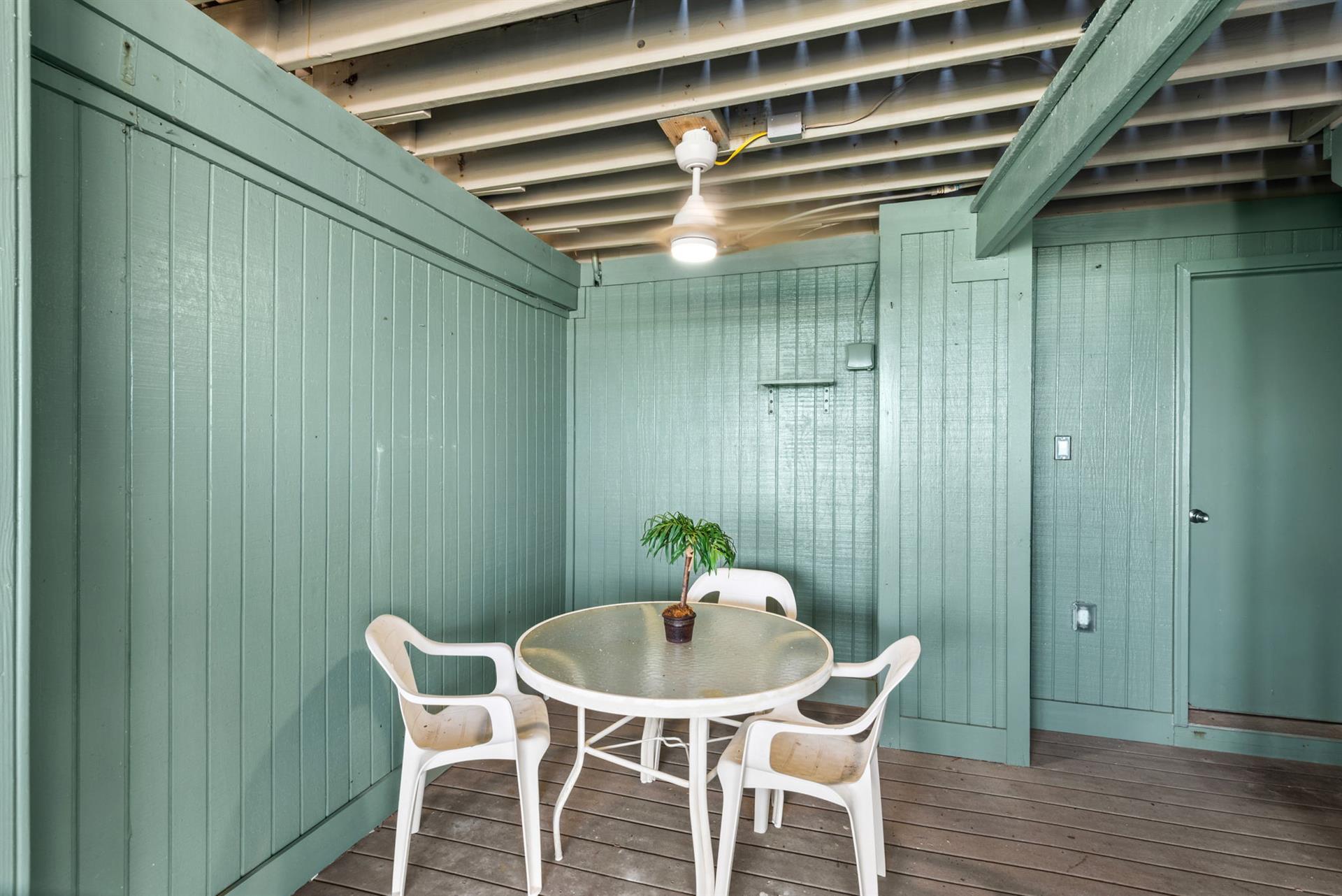 Covered patio with table and chairs for card games or cocktails and an outdoor shower to rinse the days sand away