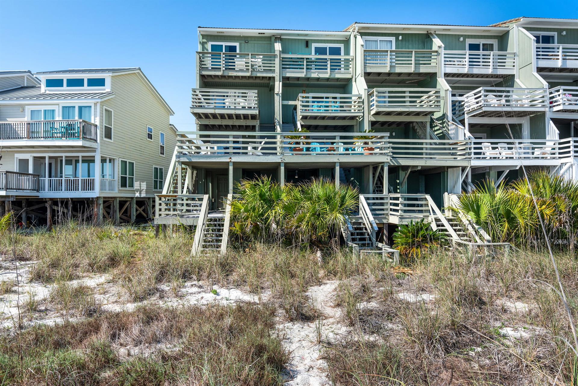 Beachfront rental homes with direct access to pristine sandy shores and native dune vegetation.