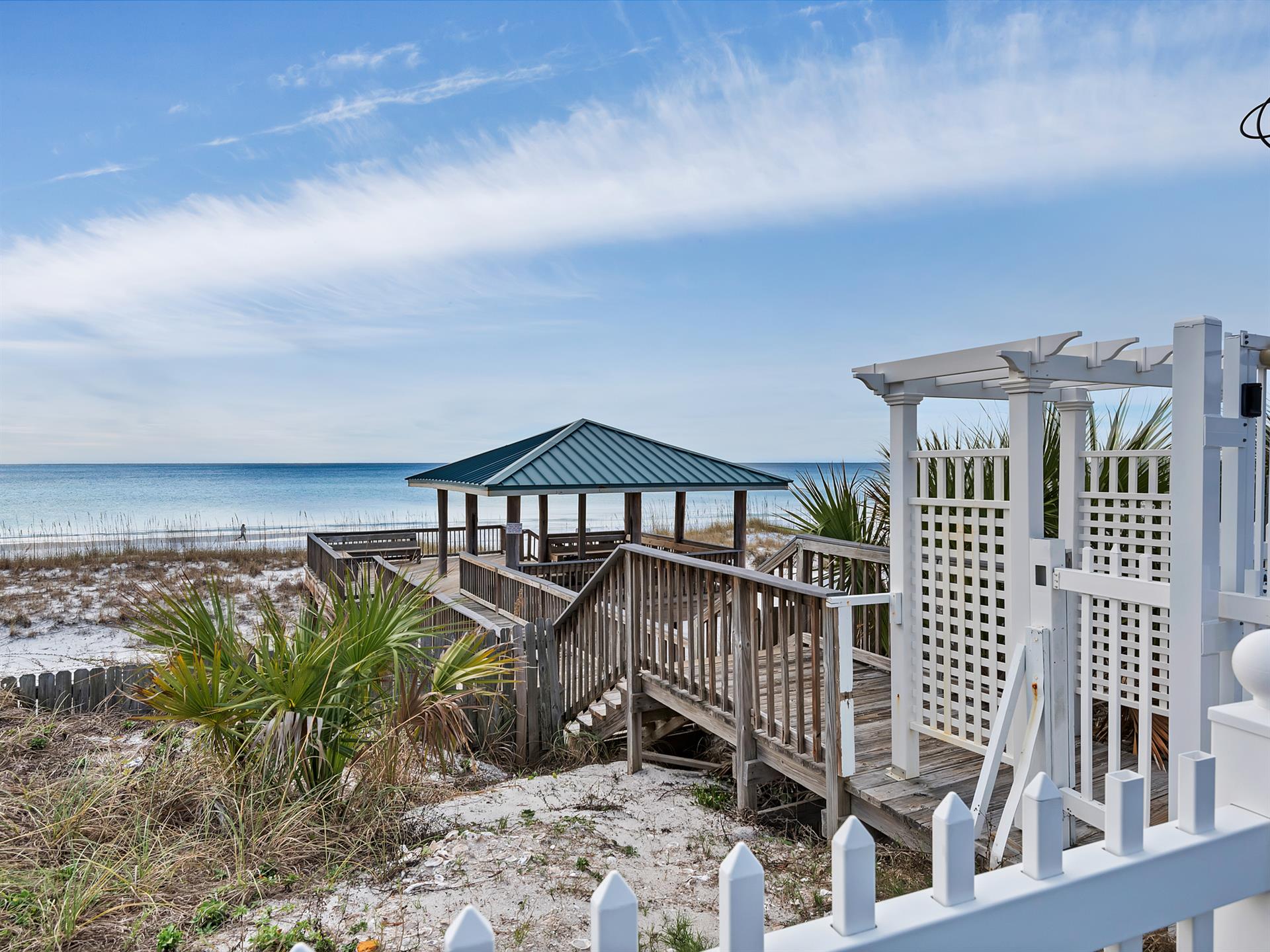 Beachfront gazebo and boardwalk provide direct access to pristine white sand and emerald waters.
