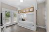 Bedroom 3 1st Fl features custom white shiplap beds with cozy storage drawers, natural light streaming through doors to the deck, and all the restful charm you need after a beach day.