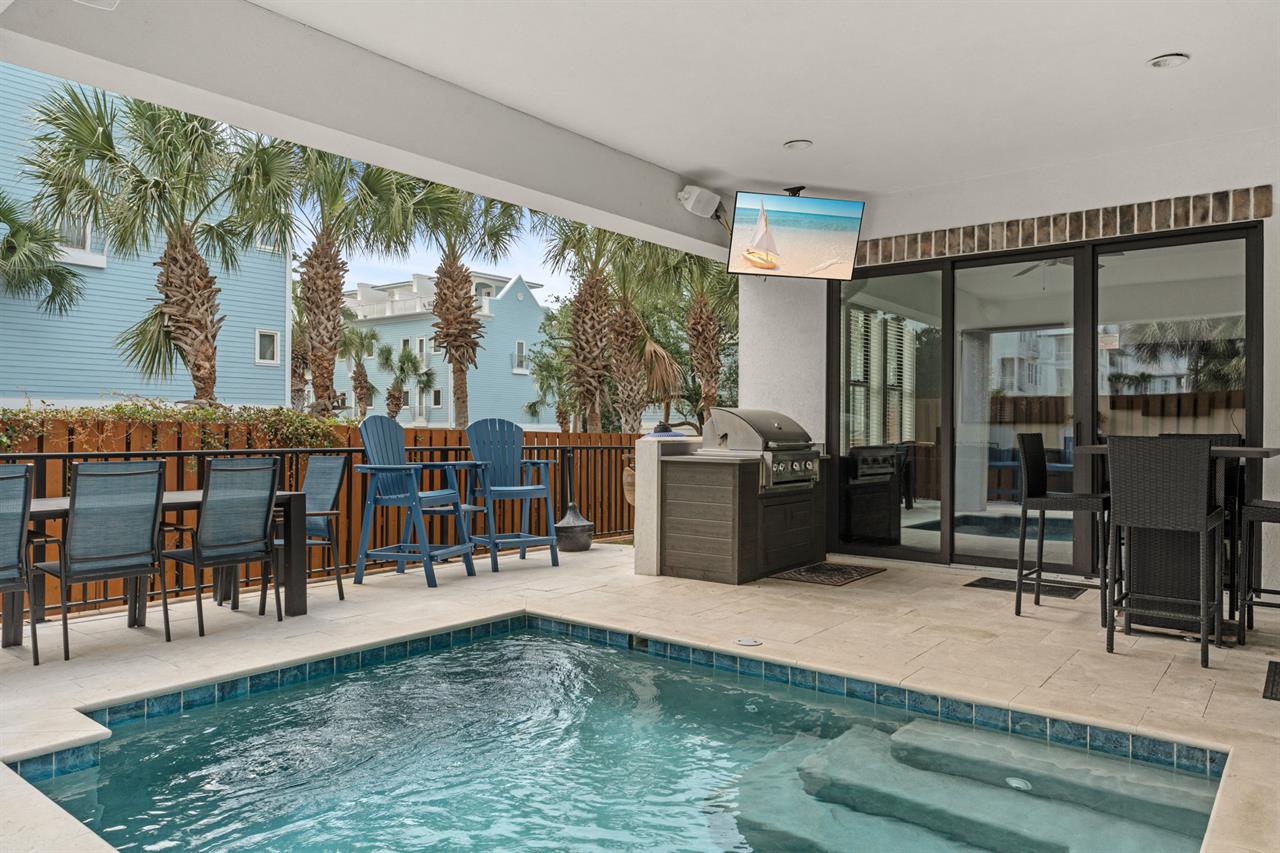 Your private oasis awaits with a sparkling pool, builtin grill, and covered patio framed by swaying palms. Perfect for relaxing or entertaining under the coastal sun.