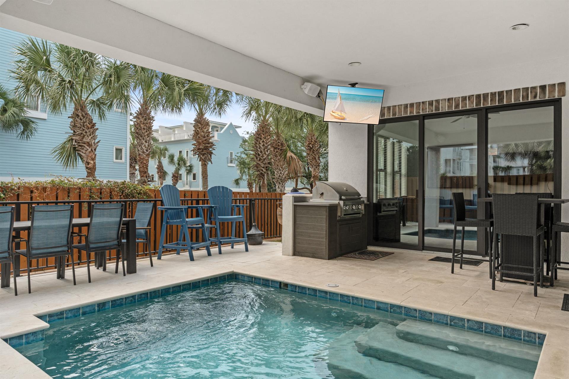 Your private oasis awaits with a sparkling pool, builtin grill, and covered patio framed by swaying palms. Perfect for relaxing or entertaining under the coastal sun.