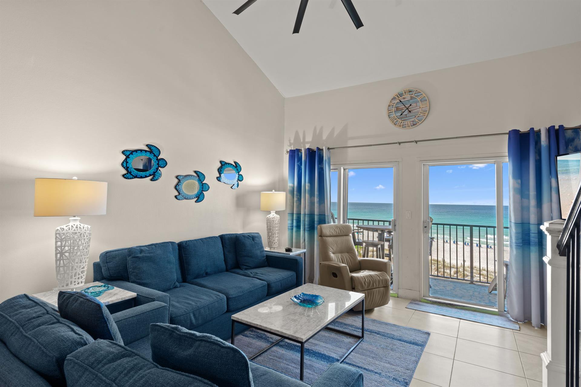Relax in your coastal living room, where oceanthemed décor and plush seating welcome you. Step through the balcony doors to feel the sea breeze and hear the waves—your beachfront escape awaits.