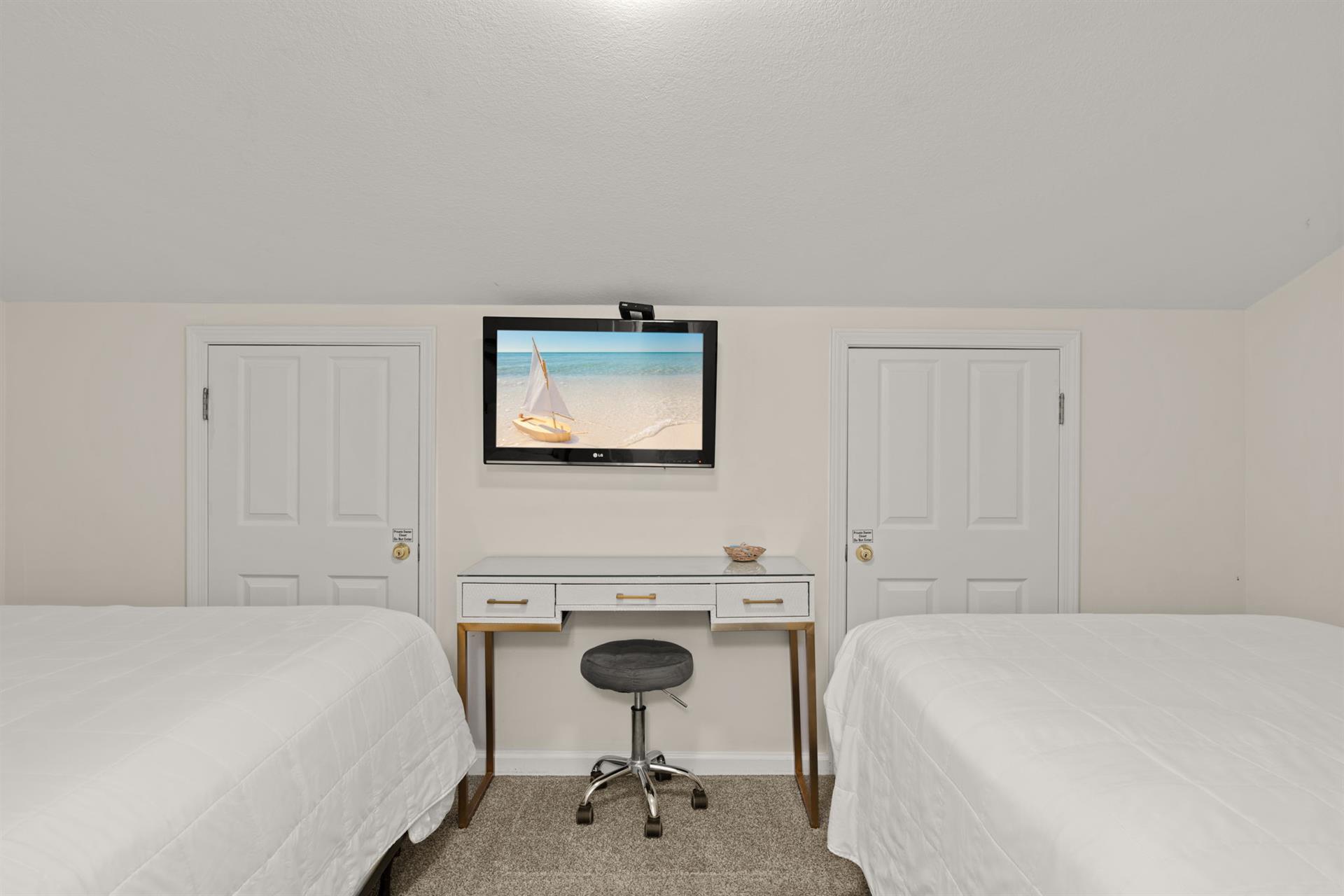 Two plush beds await your arrival, with a workspace in between for any essentials and a flatscreen TV to unwind with after your adventures.