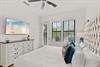 2nd floor bedroom 1 Drift off in this serene coastal bedroom with its comfortable king bed, beautiful tufted headboard, and gentle ceiling fan keeping you cool