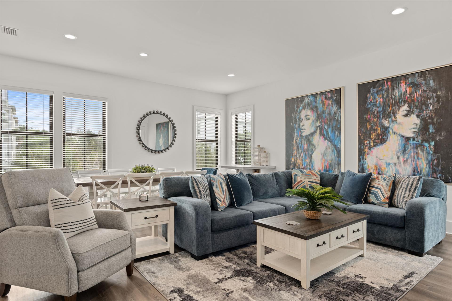Your openconcept living space welcomes you with stylish coastal charm—plush seating, contemporary art, and sunlit comfort for unforgettable moments together.