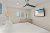 Sink into crisp white linens under a gentle ceiling fan, and wallmounted TV setting the tone for your peaceful beachside retreat.