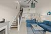 Open loftstyle retreat where soaring ceilings and coastal blues create your perfect escape. Relax on plush seating, enjoy the cozy atmosphere, and let the breezy design transport you to vacation mode