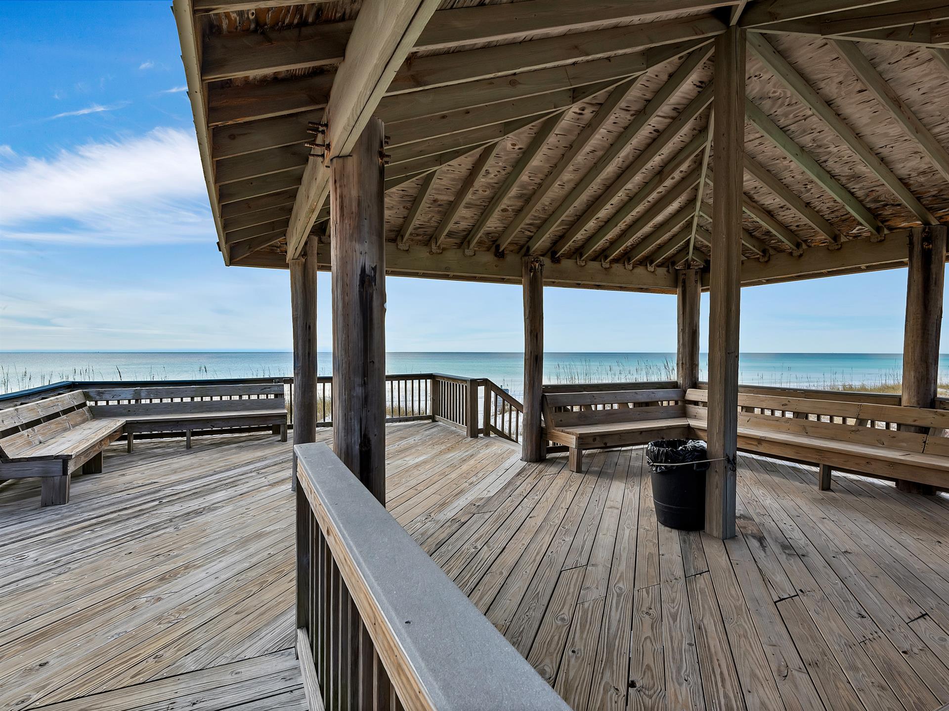 Beachfront pavilion with covered seating overlooking the Gulf and sandy shore.