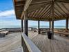 Beachfront pavilion with covered seating overlooking the Gulf and sandy shore.