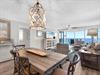 Picture yourself unwinding in this coastalchic space, where natural light flows through floortoceiling windows framing stunning gulf views. The open layout invites you to gather around the rustic d