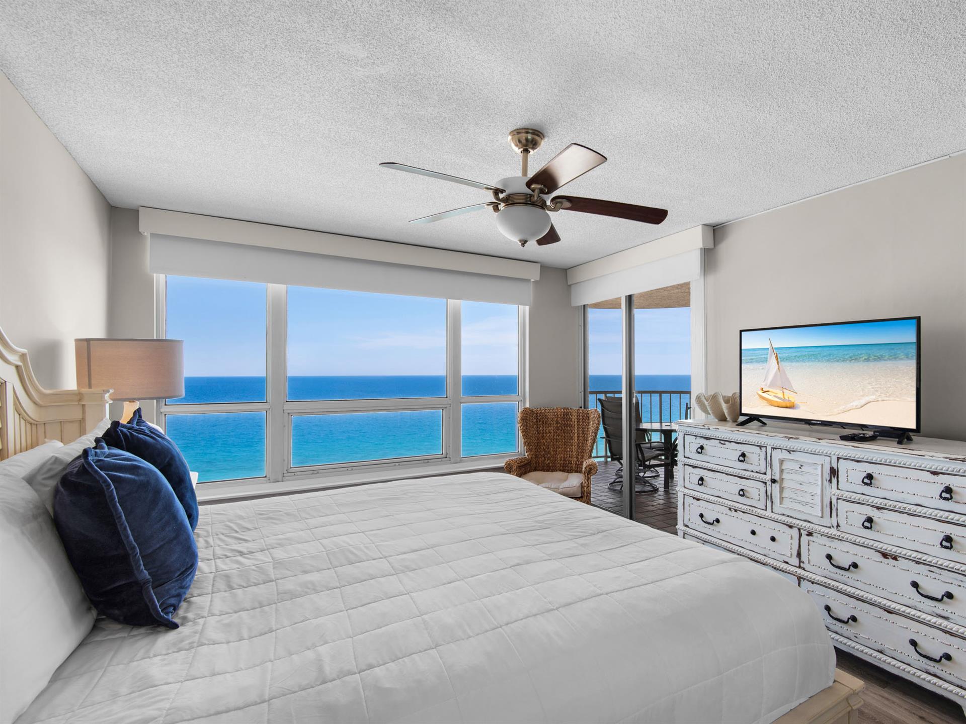 Your bedroom features a plush bed, coastal décor, and direct balcony access to enjoy the sea breeze.