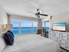 Your bedroom features a plush bed, coastal décor, and direct balcony access to enjoy the sea breeze.