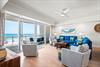 Step into your sunlit living room where cozy seating invite you to unwind after a day at the beach.