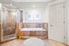 Unwind in the primary bathroom, with a soaking tub and spacious tiled shower—perfect for relaxing after a full day of adventures.