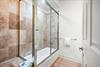 Step into the bathroom, where warm terracotta tiles embrace a spacious walkin shower.