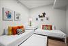 Two twin beds dressed in crisp white linens with vibrant coral and yellow accents await your family.