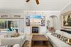 Settle into the bright living room, where beachy artwork and a cozy fireplace set the scene