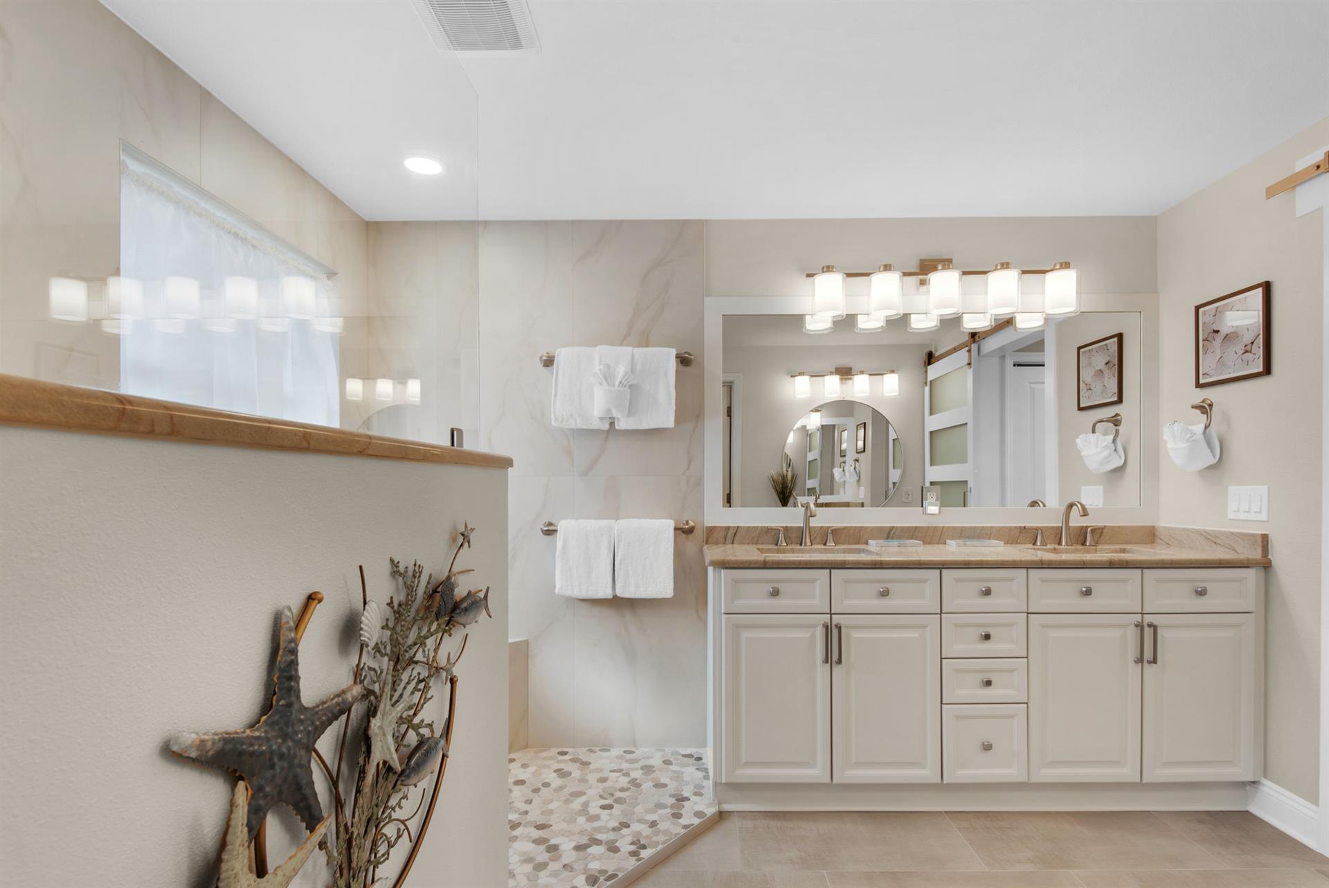 The coastalinspired bathroom features warm wood accents and soft light through frosted glass