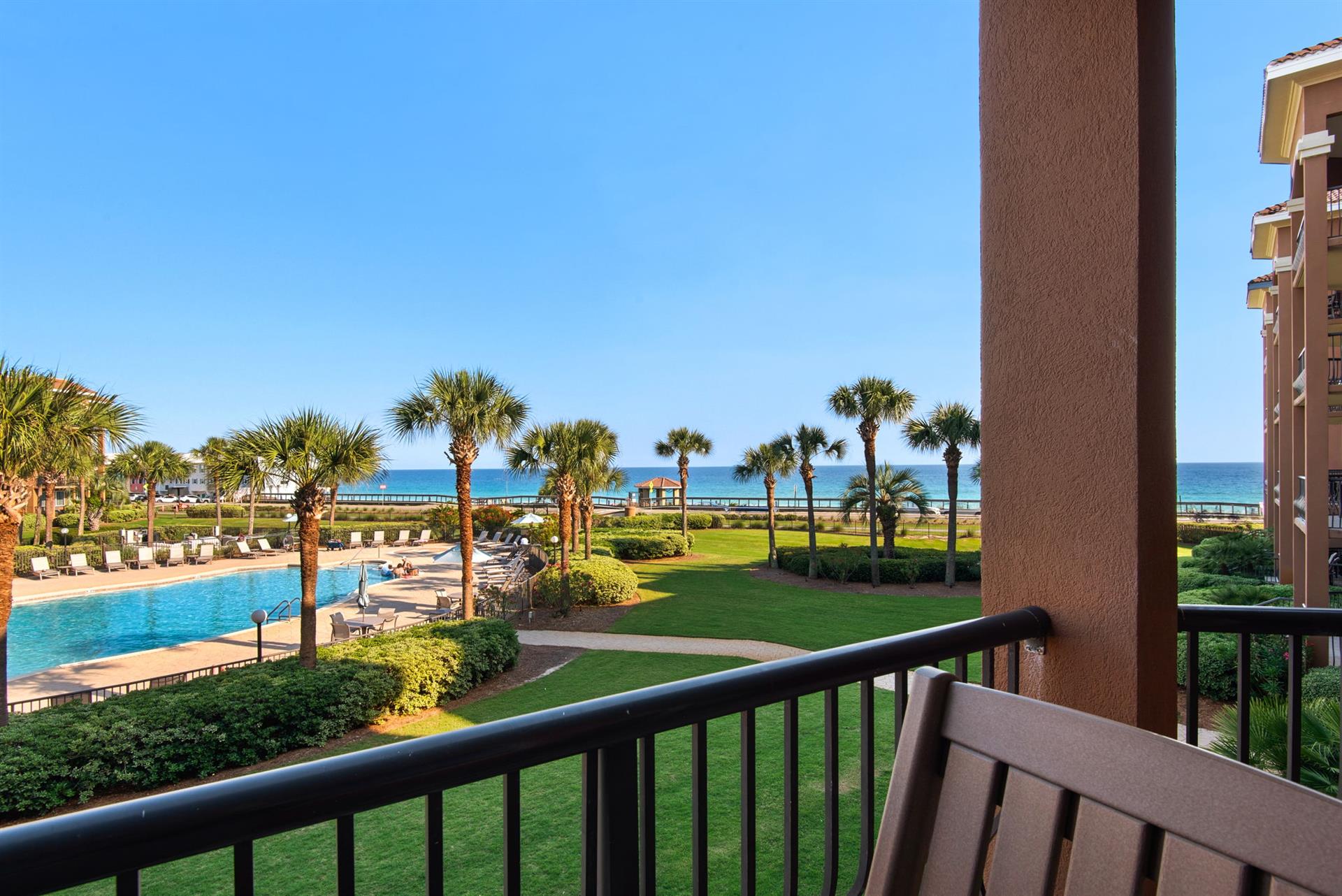 Soak in sweeping views of the sparkling pool, manicured lawns, swaying palms, and the shimmering ocean beyond from the comfort of your private balcony.