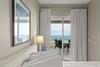 Wake up to peaceful ocean views from your bed. Soft curtains frame sliding doors leading to your private balcony, where morning coffee awaits overlooking endless blue water.