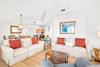 Sink into plush seating where natural textures and pops of coral invite you to unwind after sunsoaked beach days.