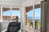 The balcony opens to coastal breezes, perfect for morning coffee or evening relaxation.