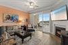 Relax in the bright living room with coastal décor, plush seating, and a cozy fireplace.